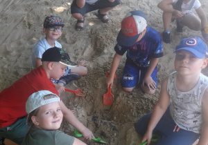 Dzieci szukają kości dinozaurów.